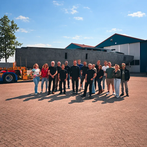Een groep medewerkers buiten bij een carbon casco en de werkplaats