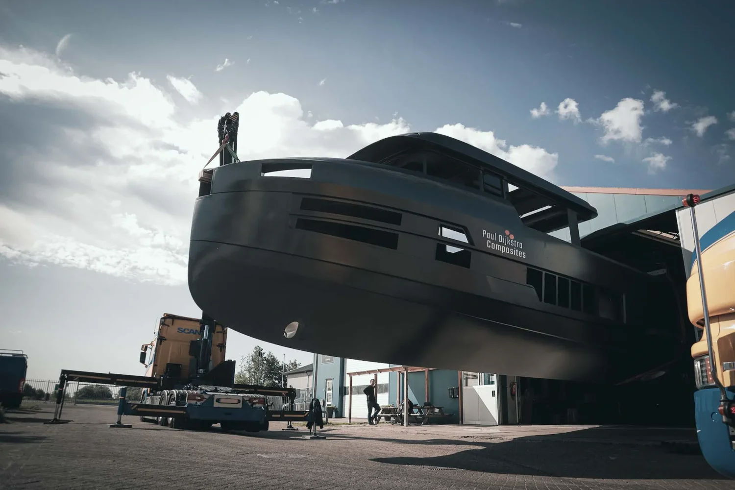 Dark boat hull suspended from lifting straps