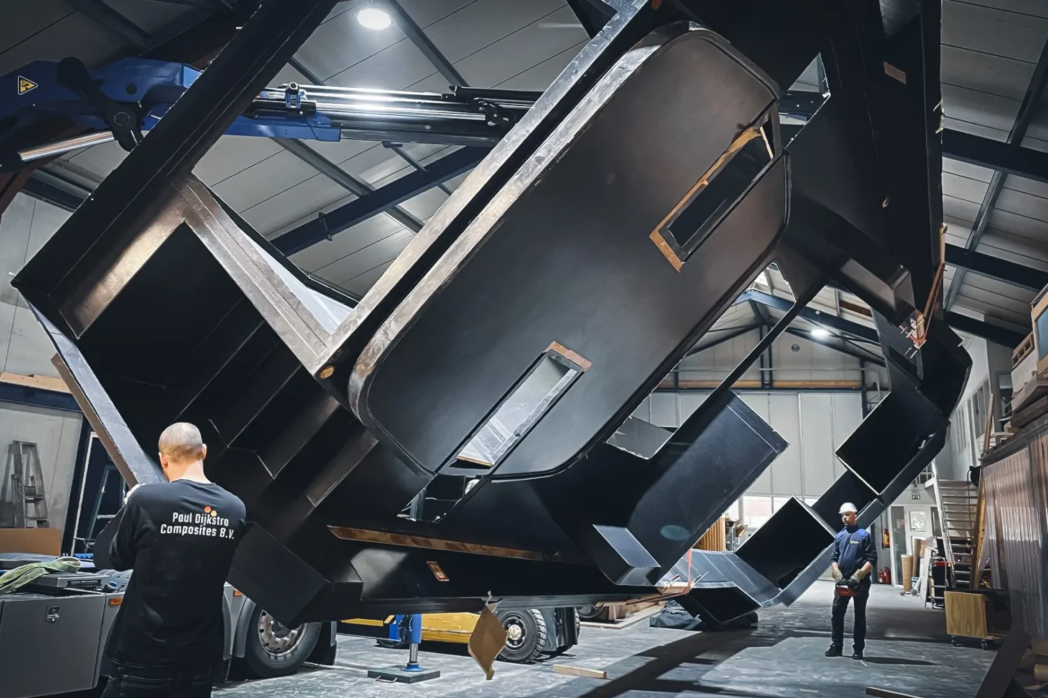 Large boat component being tilted in the workshop