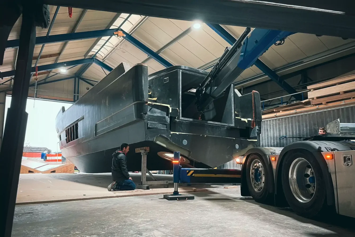Boat hull being transported by the workshop door