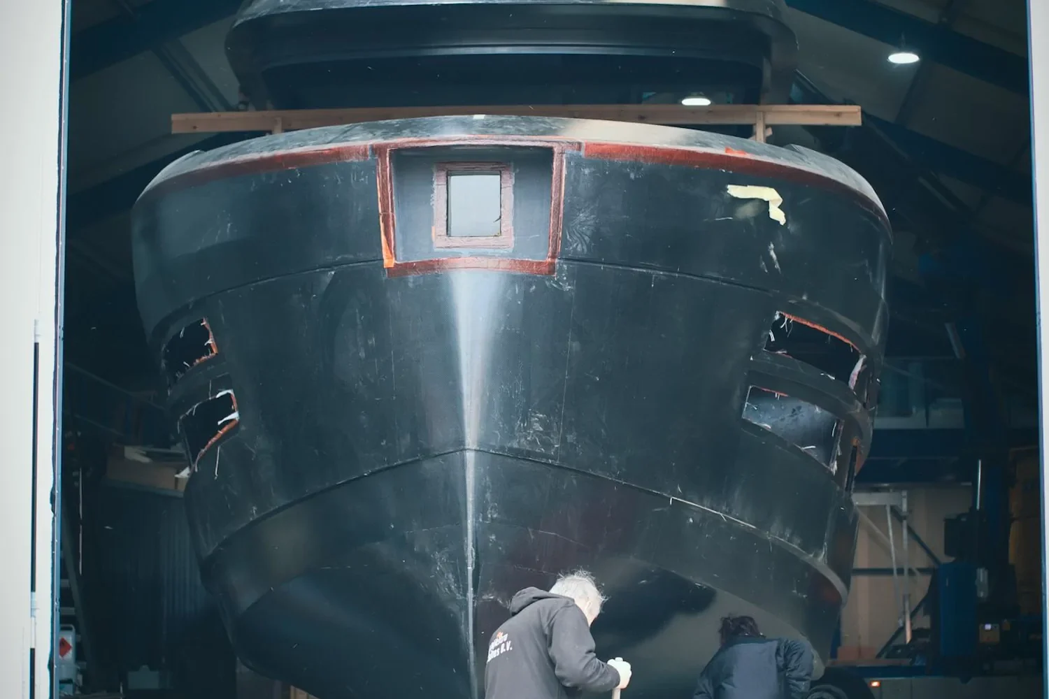 Boat hull with lifting straps in the workshop