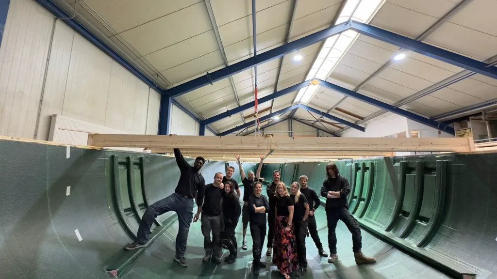 Team in an open boat hull in the workshop
