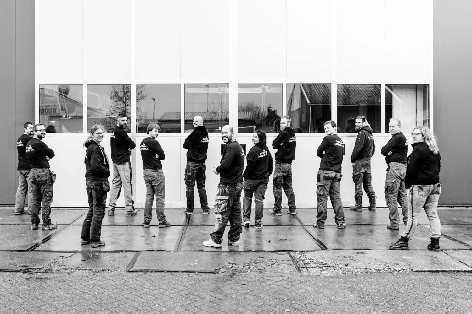 Black-and-white photo of employees in front of the workshop
