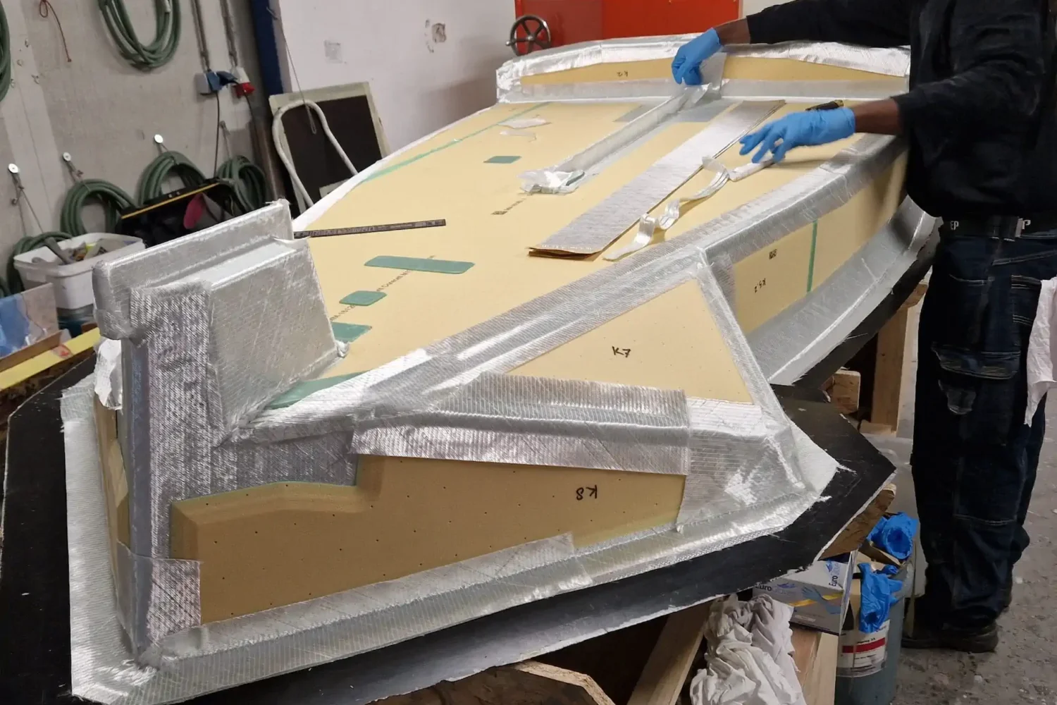 Employee working on a lightweight boat component at a workbench