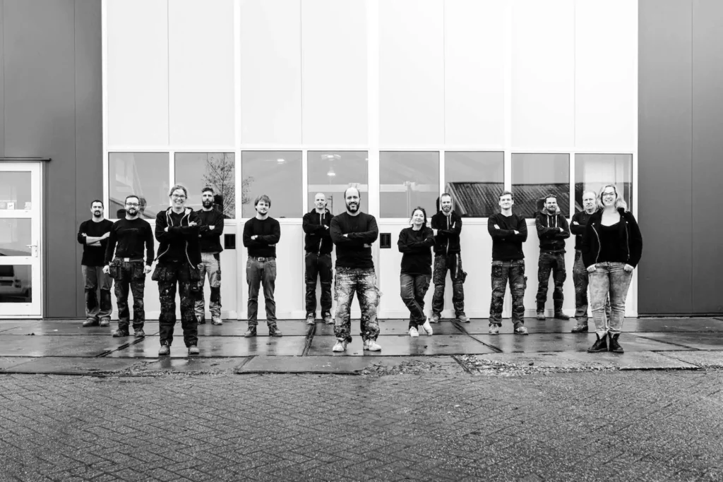 Black-and-white team photo in front of the workshop