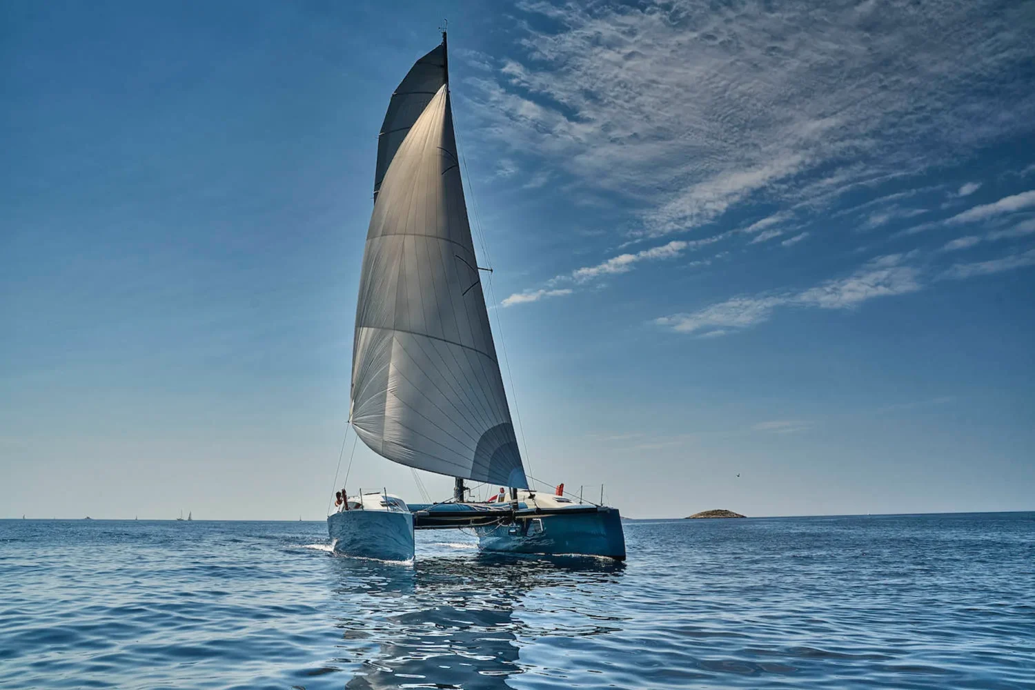 Sailing yacht with a dark sail on open water