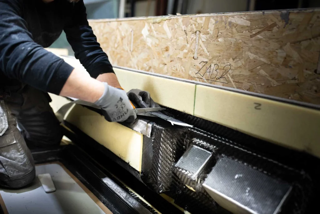 An employee’s hands working on a composite part