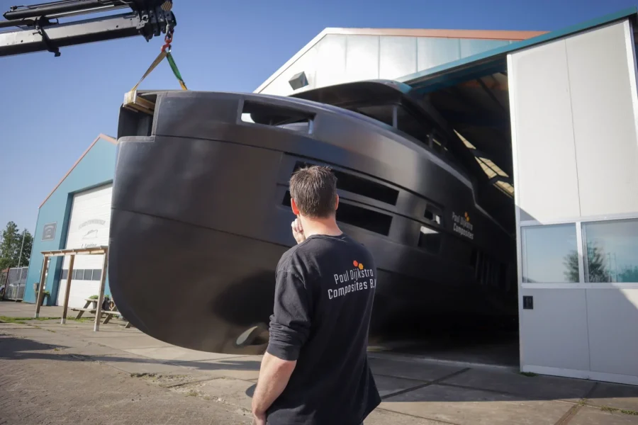 Employee looking at a boat hull by the workshop door