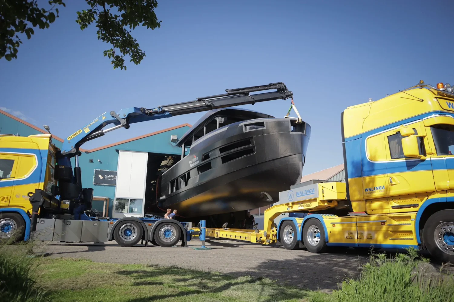 Boat hull between two crane trucks
