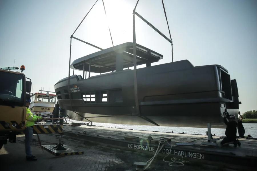 Yacht superstructure being placed on a hull using lifting straps
