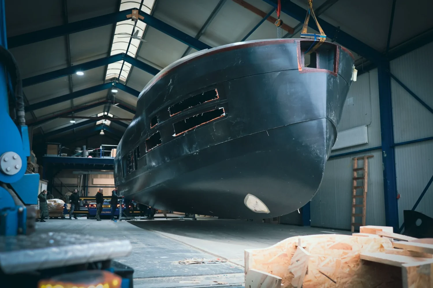 Bow of a dark yacht hull in the workshop