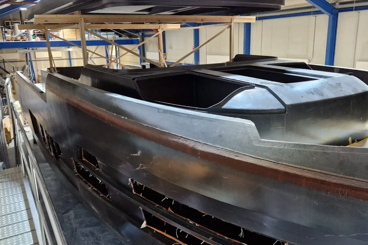 Dark boat hull and separate deck in the workshop