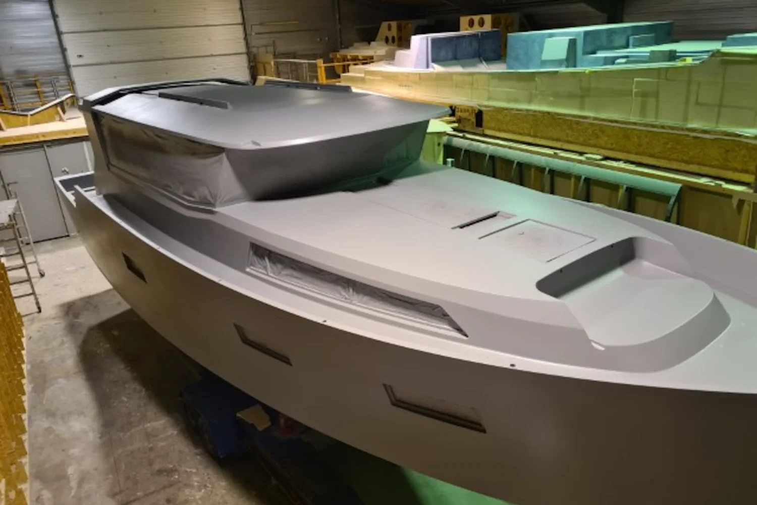 Grey boat hull with an open cockpit under construction