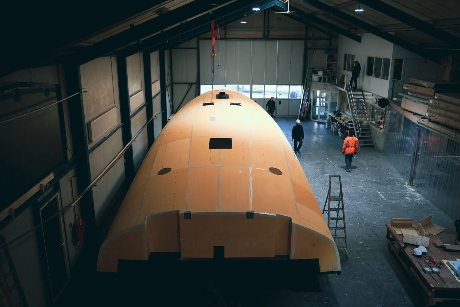 Two boat hulls in a large workshop