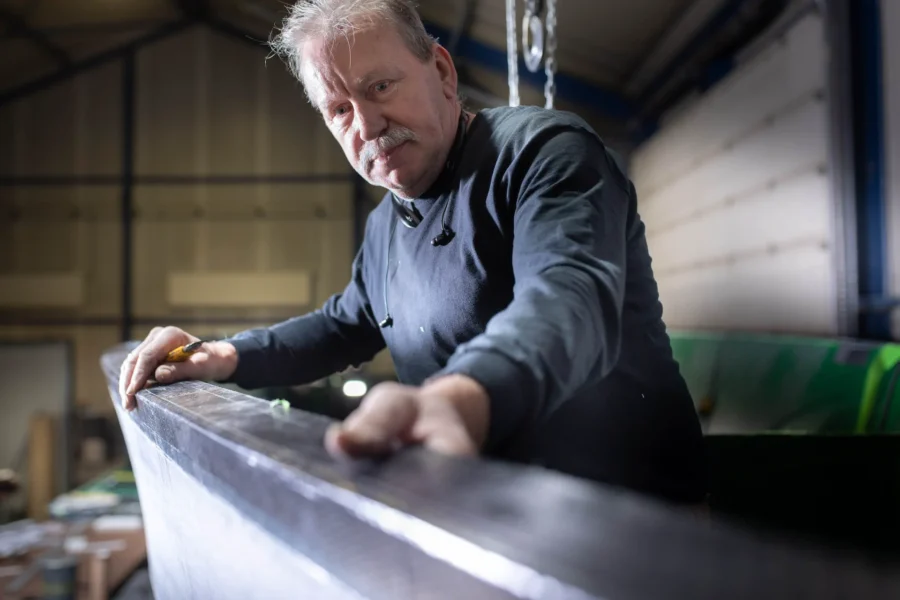 Employee inspecting a long composite component
