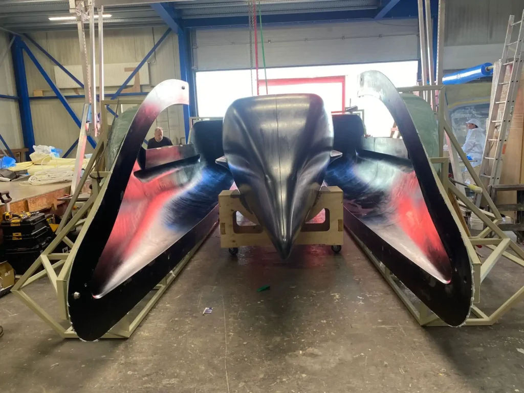 Dark boat hulls lined up in the workshop