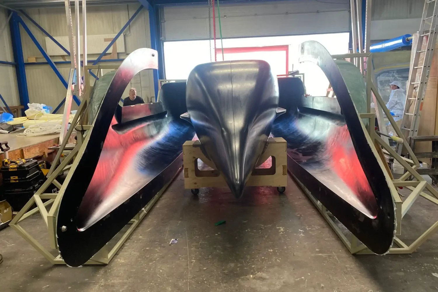 Dark boat hulls lined up in the workshop