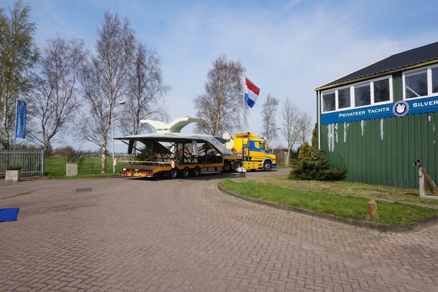 Boat component being transported in front of the workshop