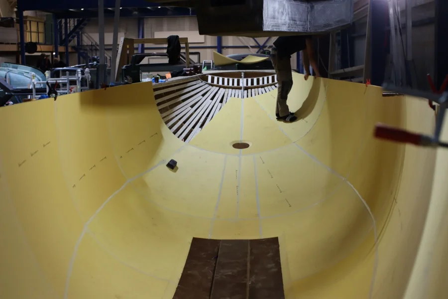 Inside of a yellow boat hull with bulkheads