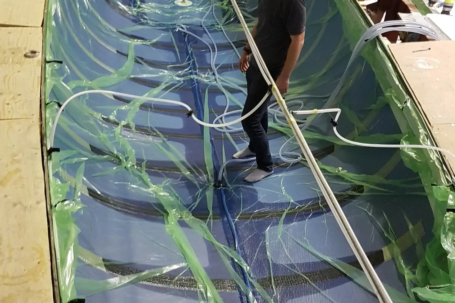 Boat hull with vacuum bagging film and connected hoses