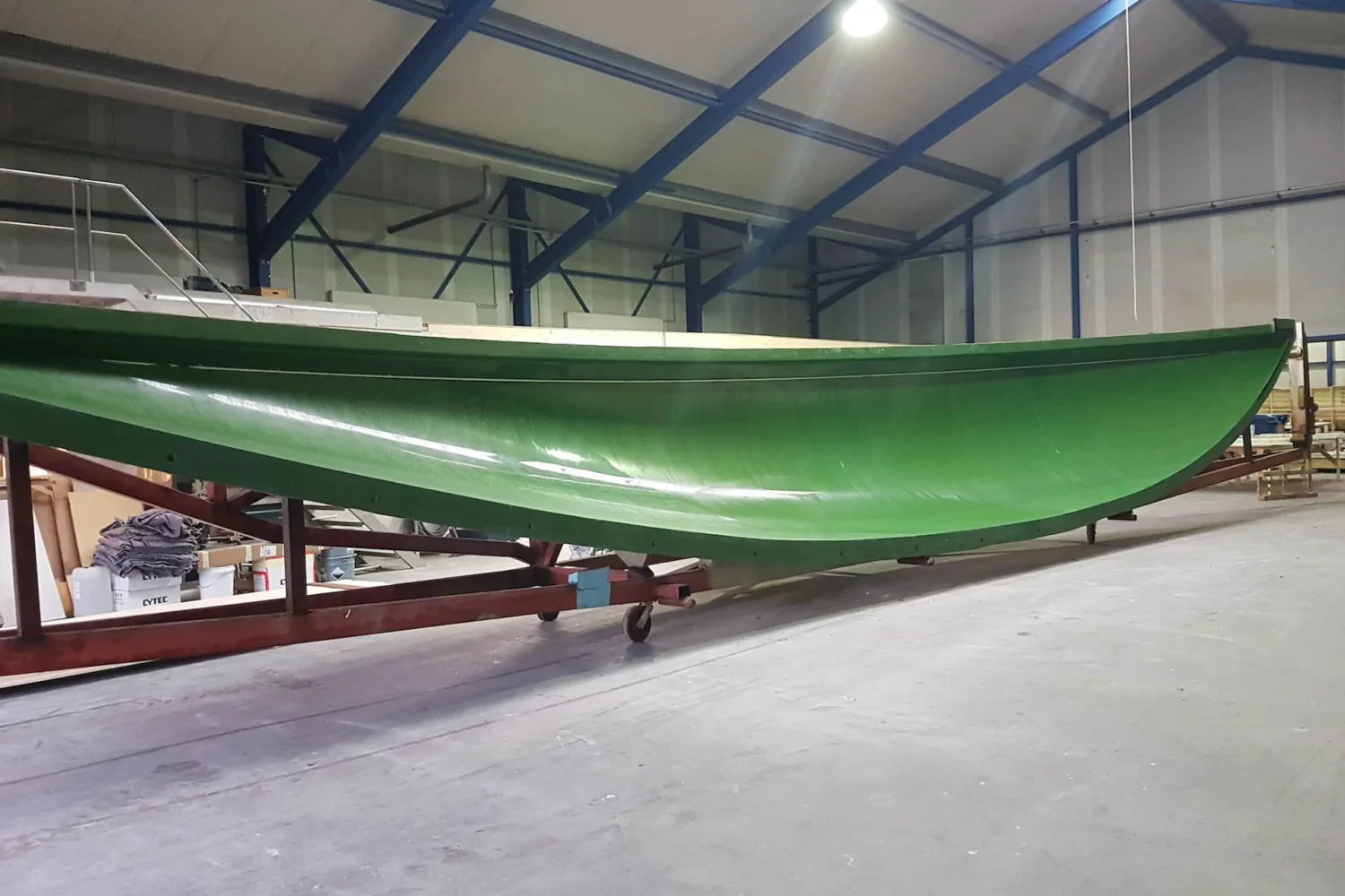 Green boat hull on supports in the workshop