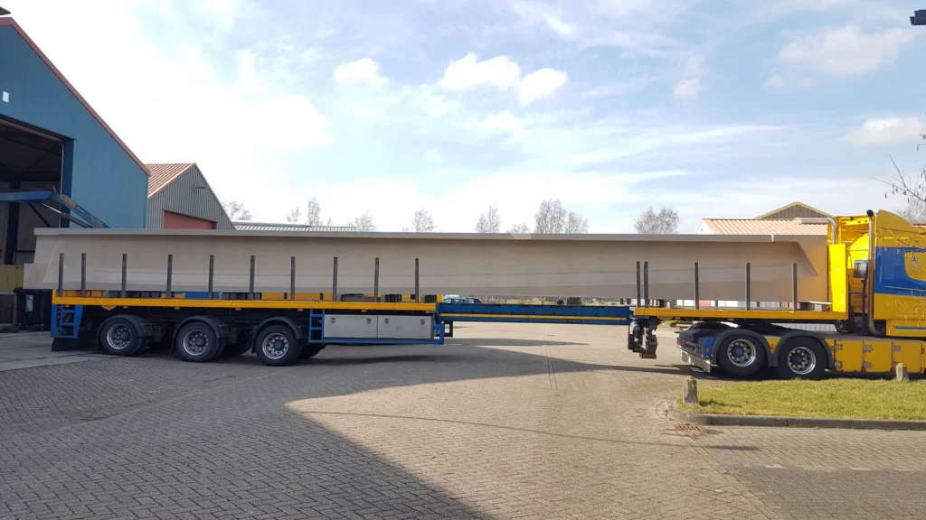 Long composite component on a low-loader