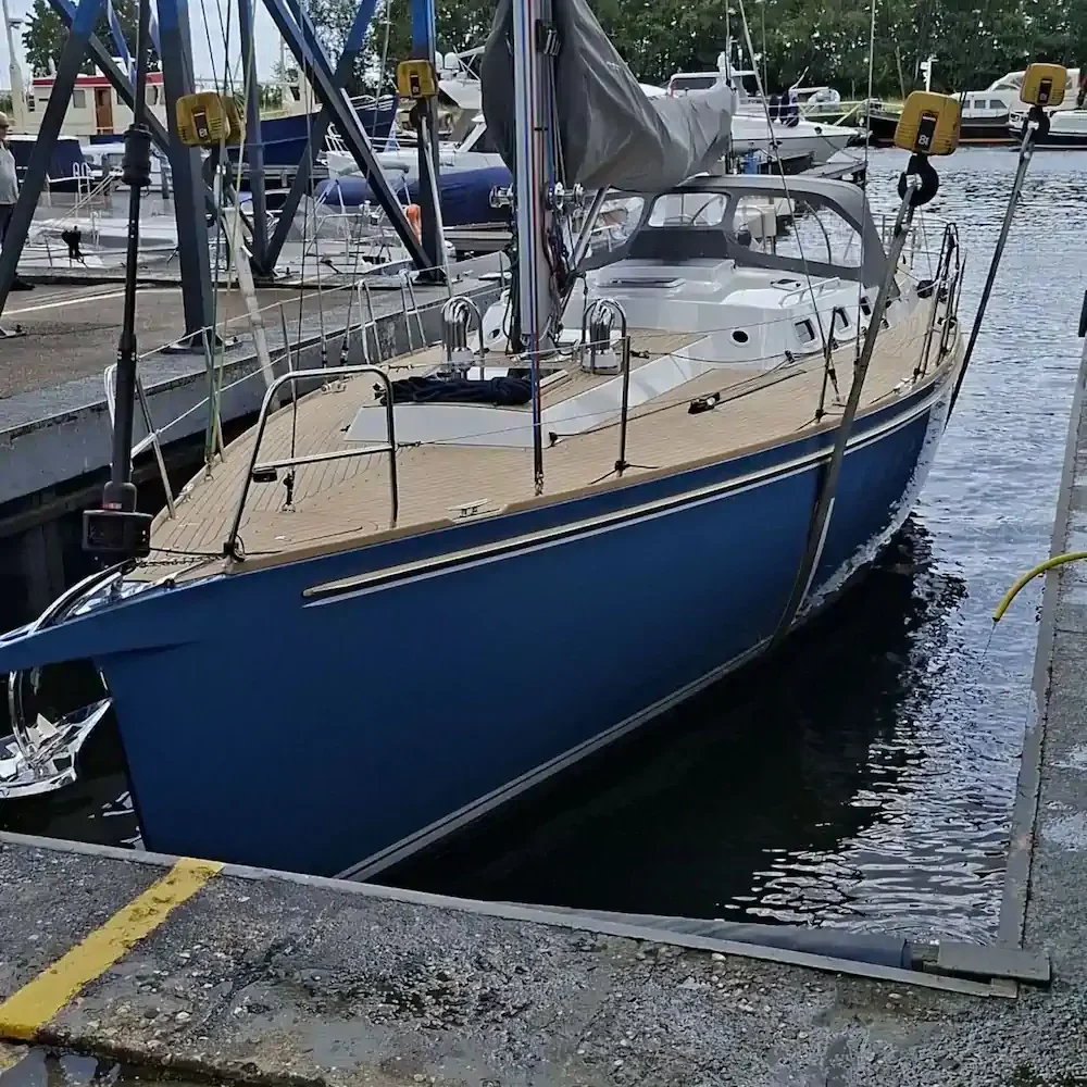 Blue sailing yacht alongside a pier