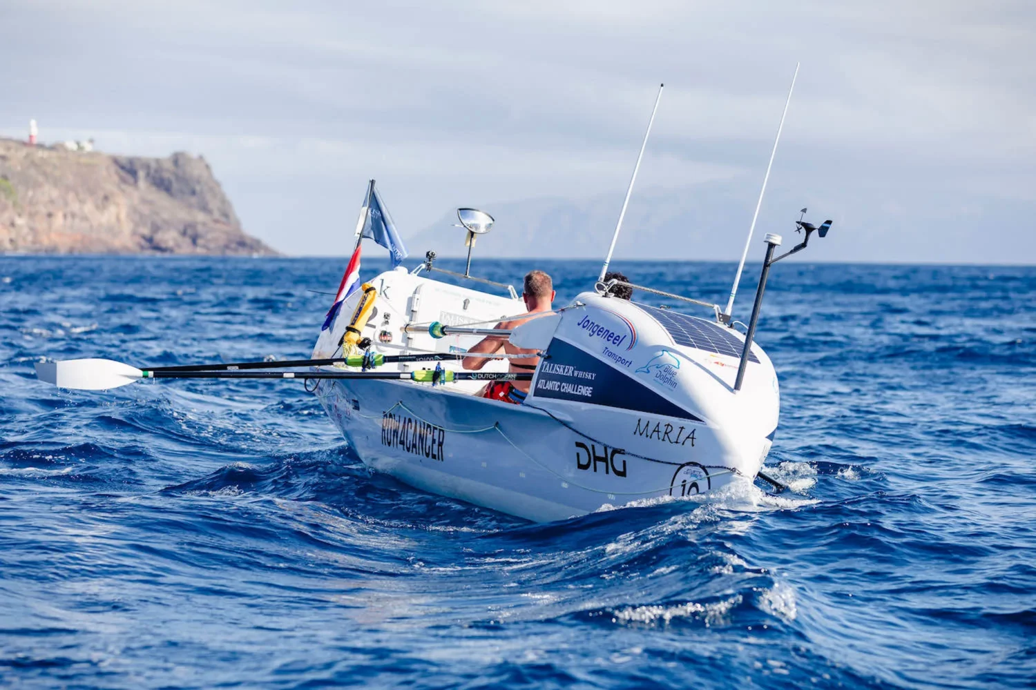 White ocean rowing boat with two rowers at sea