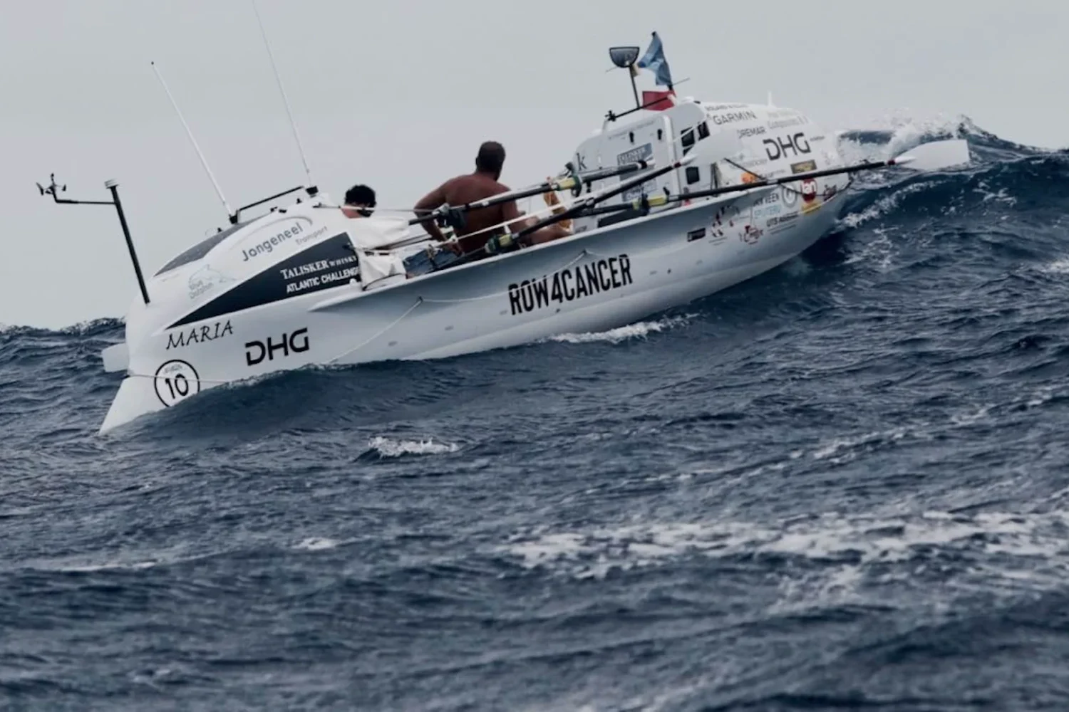 Ocean rowing boat with rowers on choppy water