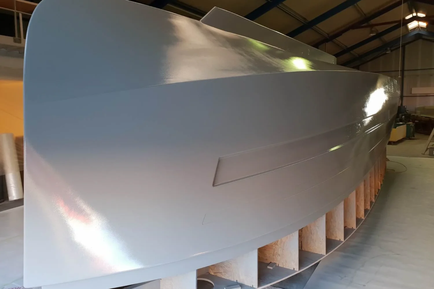 Grey boat hull on a wooden building frame