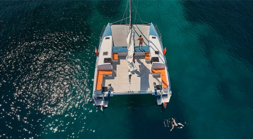 Catamaran seen from above on clear blue water