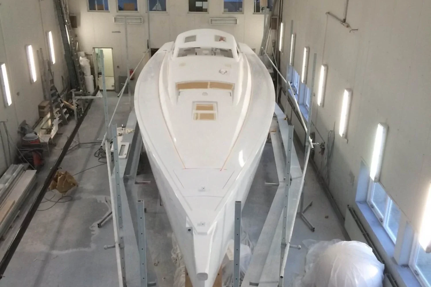 Boat hull seen from above in a brightly lit workspace