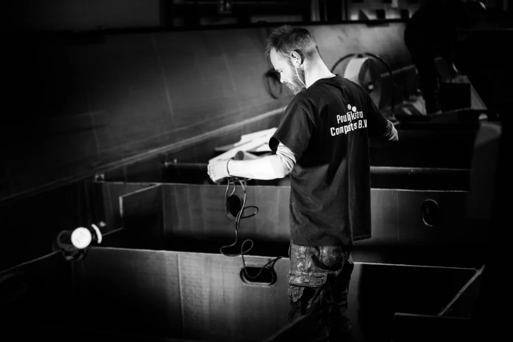 Employee working inside a dark boat structure